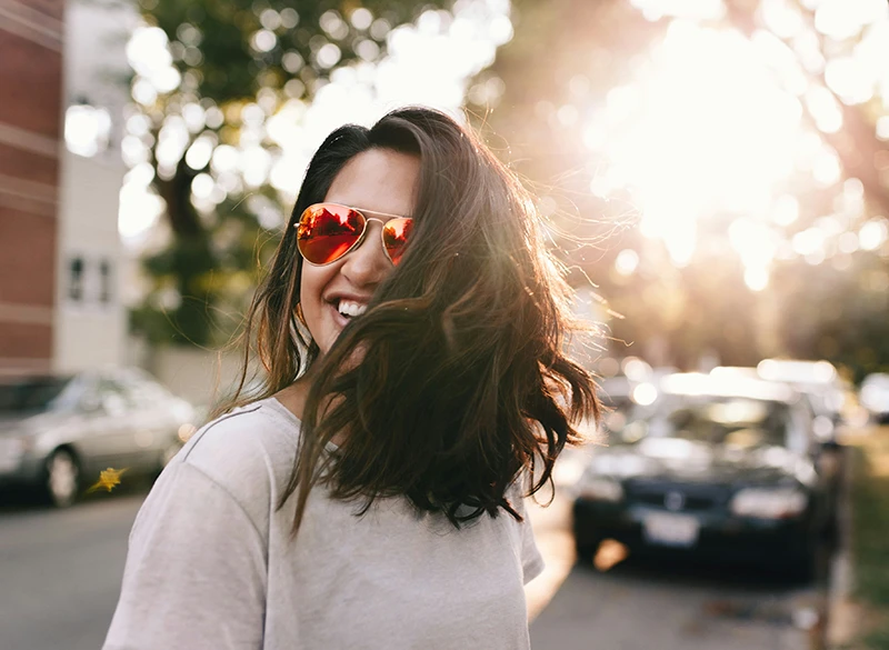 A happy woman with sunglasses on the street